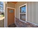 Inviting entryway featuring a stylish wood door, stone accents and a bright window for natural light at 140 Swimmers Ln, Salisbury, NC 28146