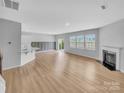 Bright, open-concept living area with hardwood flooring, a fireplace, and large windows at 151 Slip Shot Ln, Troutman, NC 28166