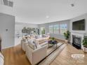 Staged living room featuring hardwood floors, white sofas, fireplace, and natural light at 151 Slip Shot Ln, Troutman, NC 28166