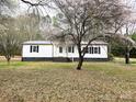 Inviting home exterior featuring a manicured lawn and mature tree, enhancing the property's curb appeal at 1607 W Nc 27 Hwy, Lincolnton, NC 28092