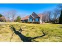 Beautiful one-story home with an expansive lawn and mature trees on a sunny day at 1636 Samaria Ln, Conover, NC 28613