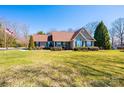 Charming one-story home with lush green lawn, manicured shrubs, and mature trees at 1636 Samaria Ln, Conover, NC 28613