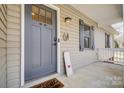 Welcoming front porch featuring a gray front door, stylish light fixture, and charming decor at 276 Rumple Hill Dr, Statesville, NC 28677