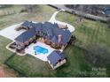 Aerial view of a sprawling estate with lush landscaping, a pool, and a circular driveway at 3200 Beaty Rd, Gastonia, NC 28056