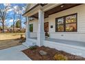 Inviting front porch with white pillars, a decorative wood ceiling, and beautiful landscaping at 3324 Flamingo Ave, Charlotte, NC 28205