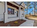 Inviting white brick front porch featuring a covered entry, stately columns, and manicured landscaping at 3324 Flamingo Ave, Charlotte, NC 28205