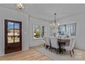 Sunlit dining room with a wood table, six chairs, a chandelier and wood door at 3328 Flamingo Ave, Charlotte, NC 28205
