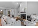 Beautiful open-concept living room with a fireplace, hardwood floors, stylish furniture, and access to dining area at 3328 Flamingo Ave, Charlotte, NC 28205