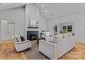 Bright living room featuring a cozy fireplace, hardwood floors, vaulted ceilings, and stylish neutral furniture at 3328 Flamingo Ave, Charlotte, NC 28205