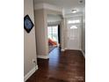 Inviting foyer with hardwood floors leading to a bright playroom through an arched entrance and a front door with sidelight at 3500 Exbury Gardens Dr, Waxhaw, NC 28173