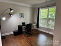 Bright office space featuring hardwood floors, a large window, and a modern workspace at 3500 Exbury Gardens Dr, Waxhaw, NC 28173