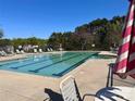 Outdoor community pool with lounge chairs and shade umbrellas on a sunny day at 4095 Harmattan Dr, Denver, NC 28037