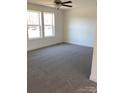 Bright, spacious bedroom with plush gray carpeting, ceiling fan, and ample natural light from large windows at 565 Perry Rd # 9, Troutman, NC 28166