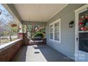 Inviting front porch with classic brick accents and a cozy bench swing and covered bench at 634 Carolina Ave, Gastonia, NC 28052