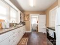 Functional kitchen featuring white cabinets, wood-look floors, and essential appliances at 707 Oakshade Ave, Kannapolis, NC 28083