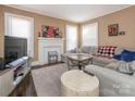 Cozy living room with hardwood floors, a decorative fireplace, and ample natural light from the windows at 707 Oakshade Ave, Kannapolis, NC 28083