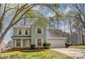 Charming two-story home featuring light blue siding, white shutters, and a well-manicured lawn, framed by tree branches at 7815 Ambleside Dr, Charlotte, NC 28216