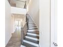 Bright foyer with dark-tread staircase and iron railing leading to the upper level at 104 Kentmore Dr, Waxhaw, NC 28173