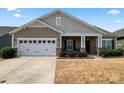 Inviting home exterior showcasing a well-manicured lawn, a two-car garage, and a cozy front porch at 11124 Chapeclane Rd, Charlotte, NC 28278