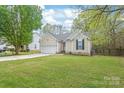 Lovely single-Gathering home showcasing a lush green lawn and an attached garage at 11404 Larix Dr, Charlotte, NC 28273