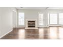 Bright living room with a fireplace, hardwood floors, and ample natural light from large windows at 11404 Larix Dr, Charlotte, NC 28273