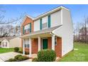 Inviting two-story home featuring a brick facade, green shutters, and a cozy front porch at 1212 Shenandoah Cir, Rock Hill, SC 29730