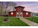 Charming red barn with white trim and crossbuck doors, set on a well-manicured lawn and a stone walkway at 1620 London Rd, Mooresville, NC 28115