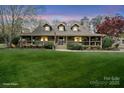 Inviting home with a spacious front porch, dormer windows, and lush landscaping, creating a warm, traditional aesthetic at 1620 London Rd, Mooresville, NC 28115