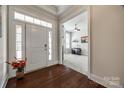 Elegant foyer with hardwood floors, a white front door with sidelights, and open view to the study at 17436 Langston Dr, Charlotte, NC 28278