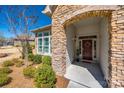 Inviting front porch with stone archway, a red front door, and manicured bushes at 17436 Langston Dr, Charlotte, NC 28278