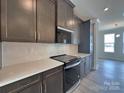 Kitchen features stainless appliances, gray cabinetry, white quartz countertops and subway tile backsplash at 2043 Clarksdale St # 31, Charlotte, NC 28206