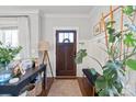 Stylish entryway featuring a dark wood door, hardwood floors, and a well-decorated console table at 209 S Gardner Ave, Charlotte, NC 28208