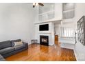 Bright living room with fireplace, vaulted ceiling, hardwood floors, and access to other rooms at 2249 Cigar Ct, Charlotte, NC 28273