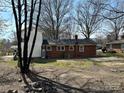 Backyard of brick home with patchy grass and bare trees at 314 N Little Texas Rd, Kannapolis, NC 28083