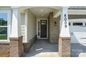 Close-up of the front door with brick accents and pillars, recessed lighting and visible house number at 4009 Grace Pointe Dr # 101, Indian Trail, NC 28079