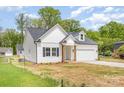 Charming home featuring a modern design, attached garage, inviting front porch, and a neatly maintained lawn at 402 Walker St, Kannapolis, NC 28081