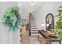 Bright entryway featuring wood-look tile floors, a stylish mirror, and stairs leading to the upper level at 11315 Magpie Ct # 3, Charlotte, NC 28215