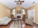 Inviting living room featuring a cozy fireplace, vaulted ceilings, and natural light at 11406 Olde Turnbury Ct, Charlotte, NC 28277