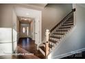 Bright foyer with hardwood floors, a decorative front door and staircase with wooden railing at 121 N Prestwick Way # 43, Mooresville, NC 28115