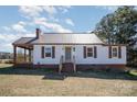 Front of home with white siding, a covered porch and brown shutters at 15 Gumtree St, Wadesboro, NC 28170