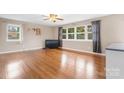 Spacious living room with hardwood floors, large windows, and a ceiling fan at 1525 16Th Avenue Nw Cir, Hickory, NC 28601