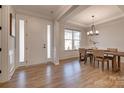 Open foyer showcasing hardwood floors, wainscoting, and a view into the dining room with abundant natural light at 15606 Walnut Hill Dr, Charlotte, NC 28278