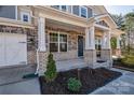 Close-up view of the front porch featuring stone and brick accents, decorative wreath, and well-maintained landscaping at 15606 Walnut Hill Dr, Charlotte, NC 28278