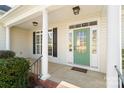 Inviting front porch featuring classic white columns, a green front door with glass, and stylish overhead lighting at 1730 Townsend Ln, Rock Hill, SC 29730