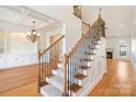 Elegant staircase with wood and iron railings leads to a spacious living area with hardwood floors and fireplace at 1730 Townsend Ln, Rock Hill, SC 29730