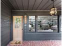 Inviting covered front porch with elegant lighting, decorative wreath, and patterned tile floor at 212 Sloan St, Belmont, NC 28012