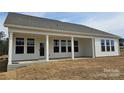 Rear elevation with porch including a view of ample windows and a sliding door with porch columns at 228 Miramar Dr, York, SC 29745
