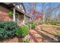 Inviting walkway leading to a charming brick home, surrounded by lush landscaping at 2324 Chestnut Ln, Matthews, NC 28104