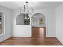 Dining room showcases wood floors, modern chandelier, and access to multiple rooms through arched doorways at 2609 Lowell Rd, Gastonia, NC 28054