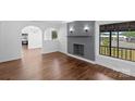 Bright living room featuring wood floors, a brick fireplace, large windows, and an open floor plan at 2609 Lowell Rd, Gastonia, NC 28054